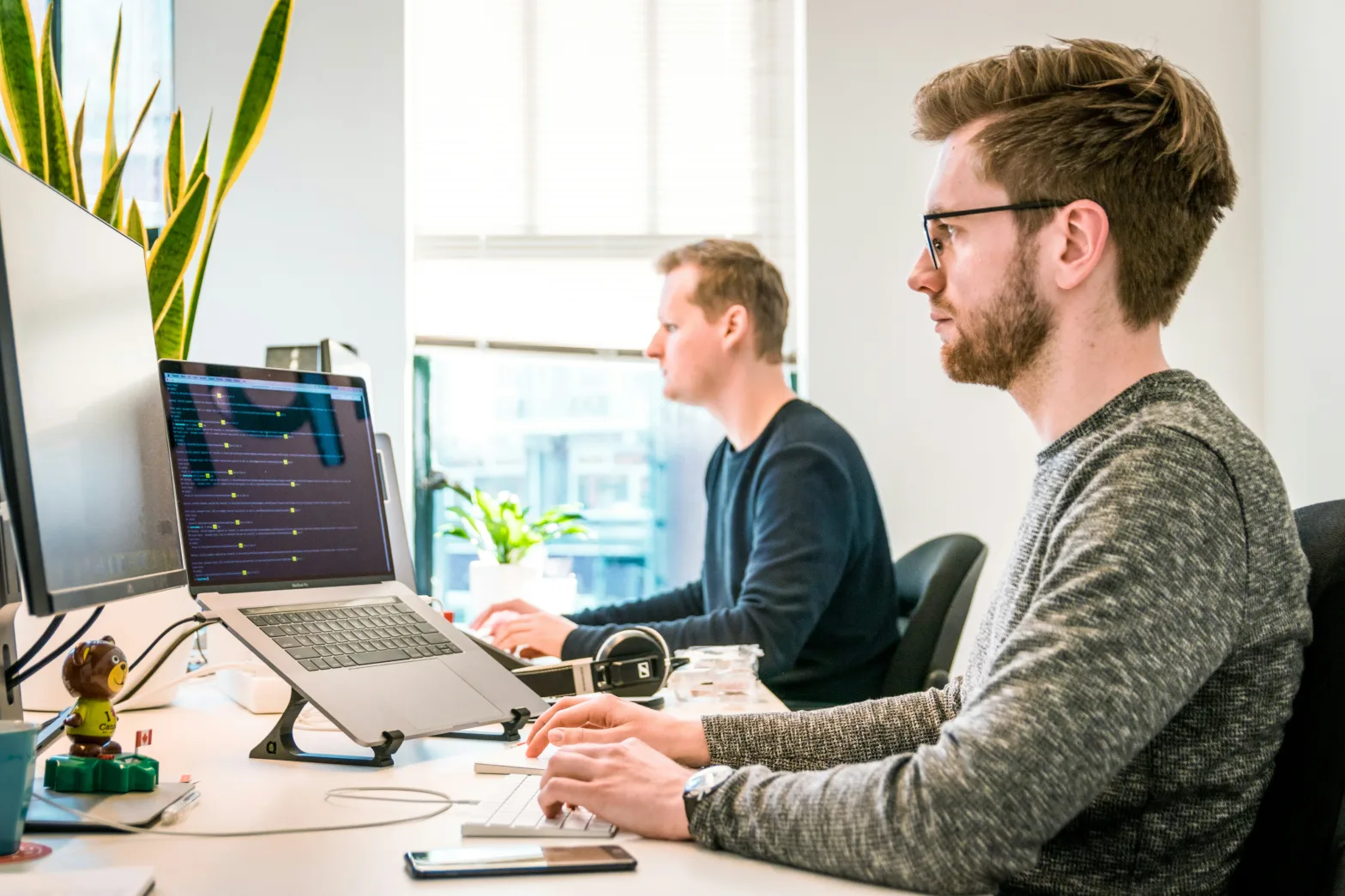 Two male coworkers on desktops working