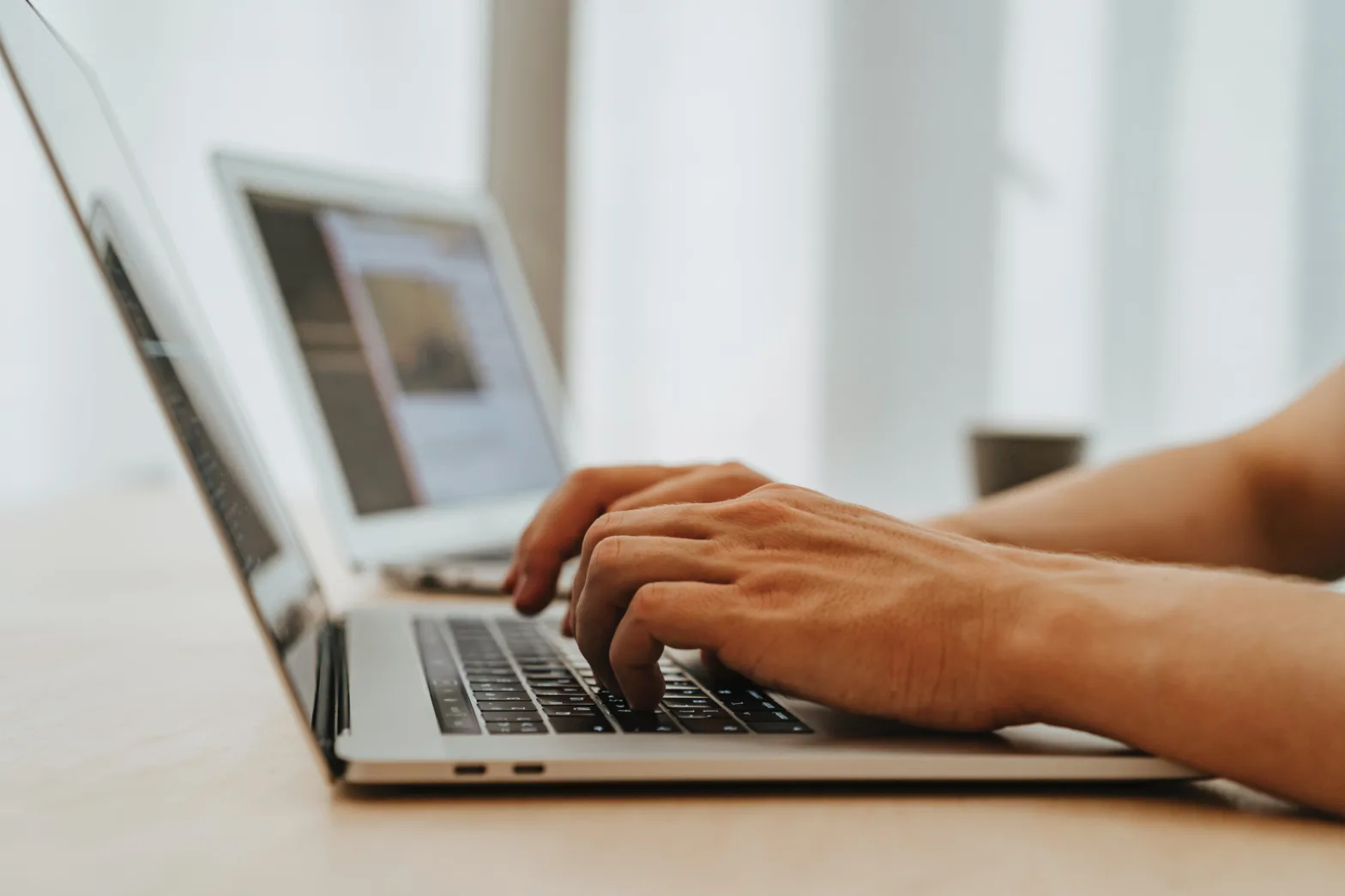 Hands typing on laptop