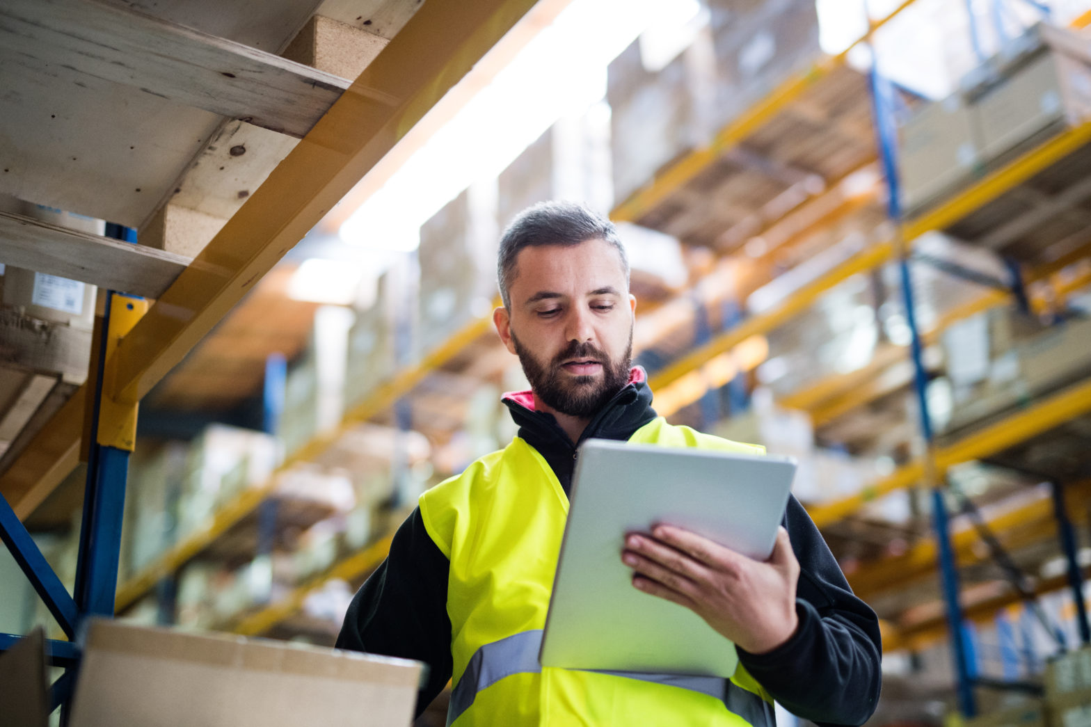 Male warehouse worker looking at a tablet