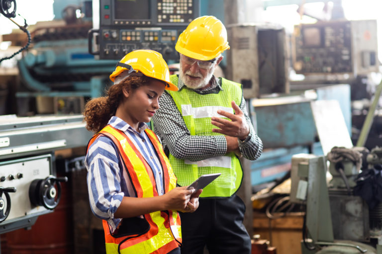 manufacturing employees looking at a tablet