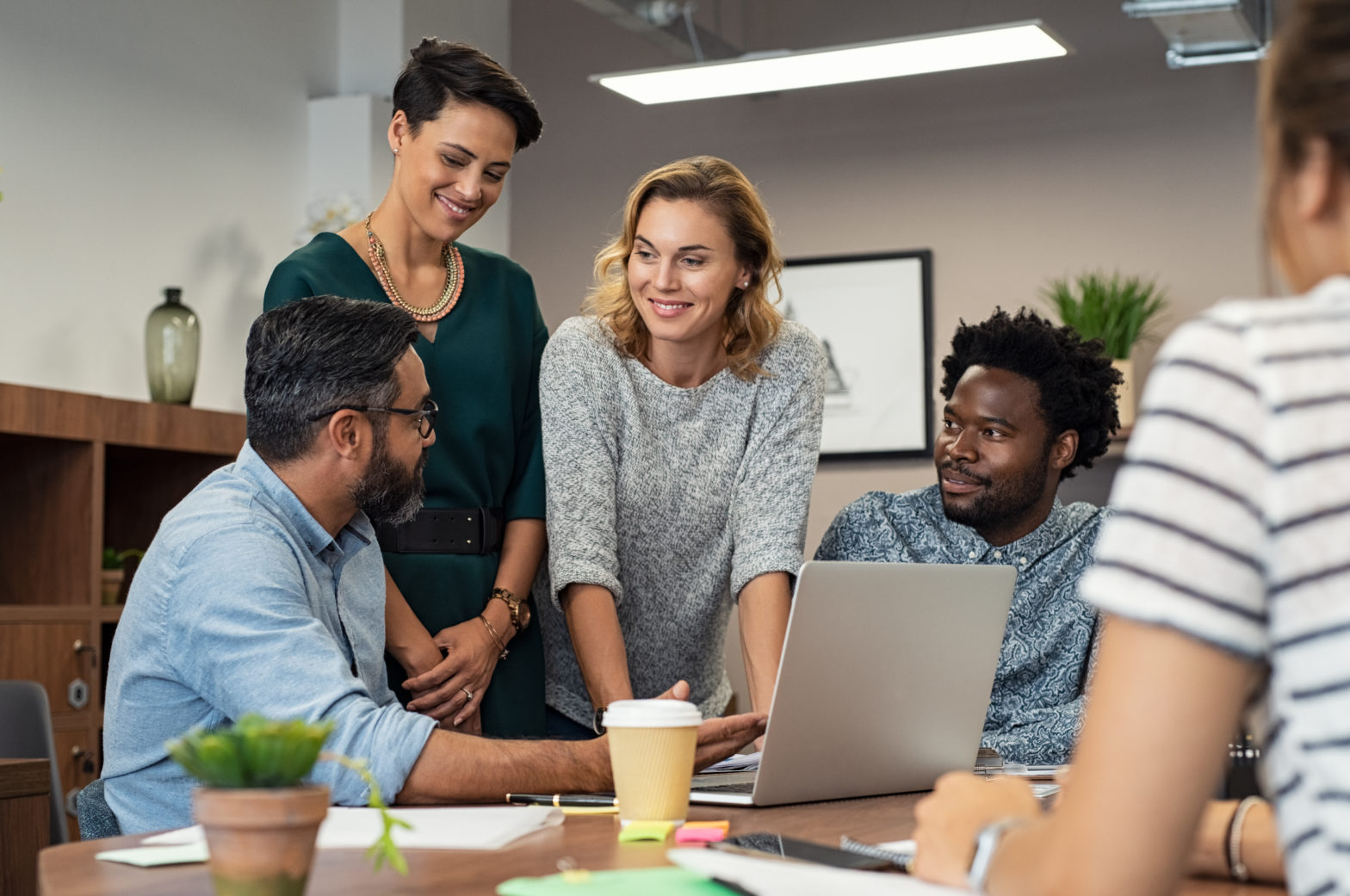 Corporate team having a discussion around a laptop