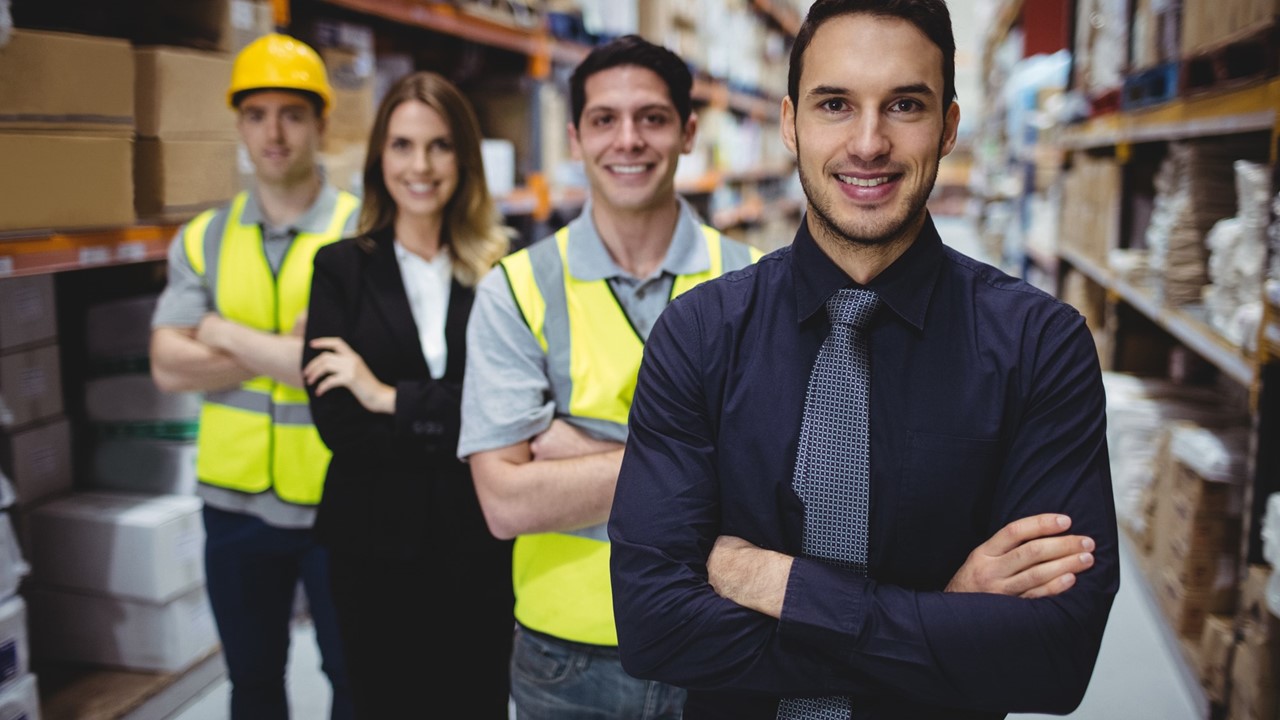 Warehouse workers and business man in warehouse