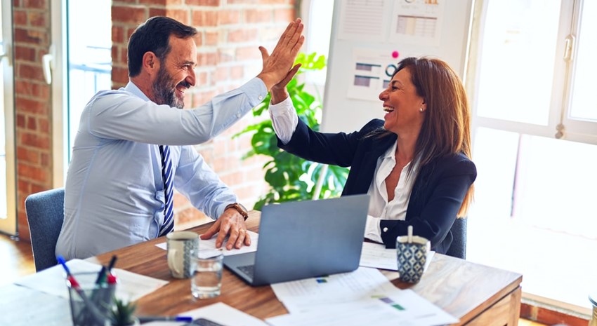 Business consultant high fiving their client at desk