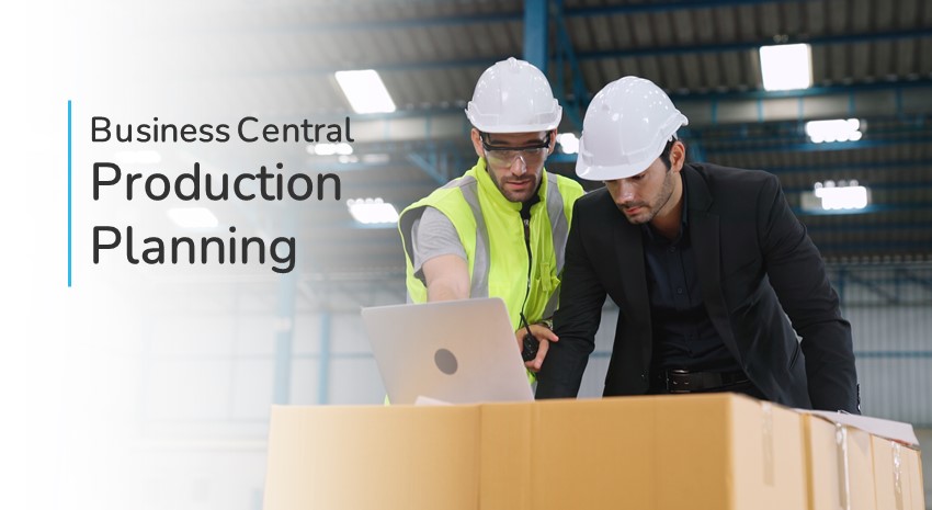 two warehouse workers looking over a laptop in a warehouse