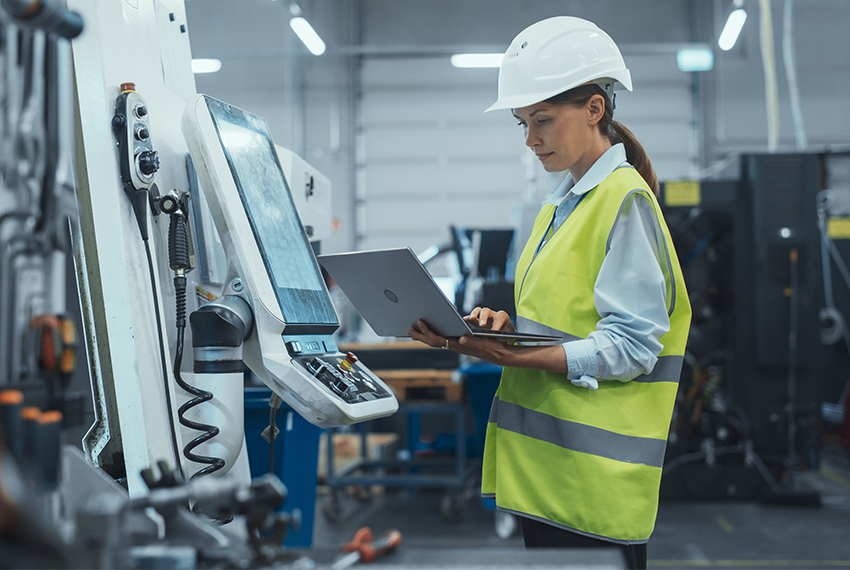 Female manufacturing employee holding laptop